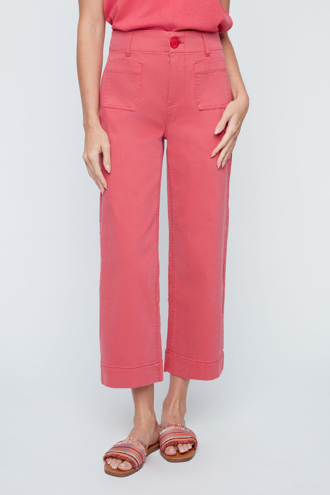Person wearing pink pants and a red top on a light gray background