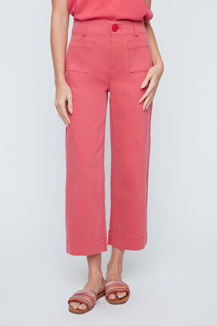 Person wearing pink pants and a red top on a light gray background