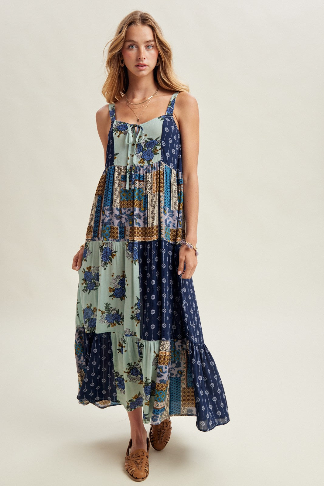 Woman wearing a long, patterned dress on a plain background