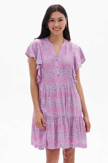 Woman wearing a pink patterned dress on a white background