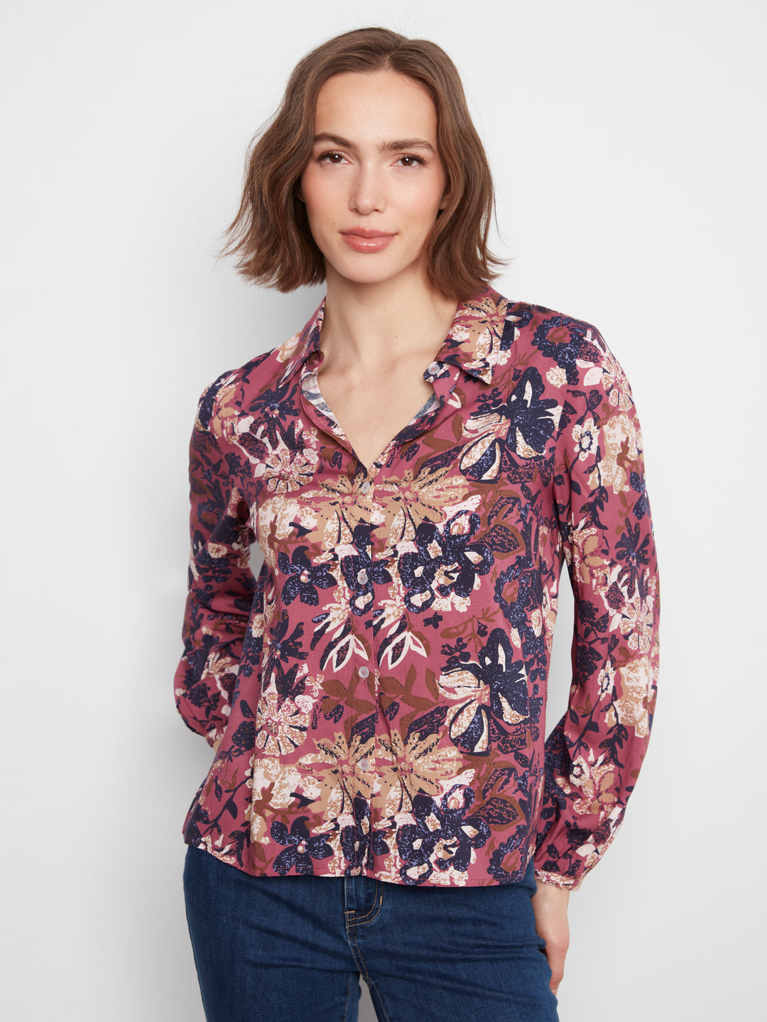 Woman wearing a floral blouse with a plain background