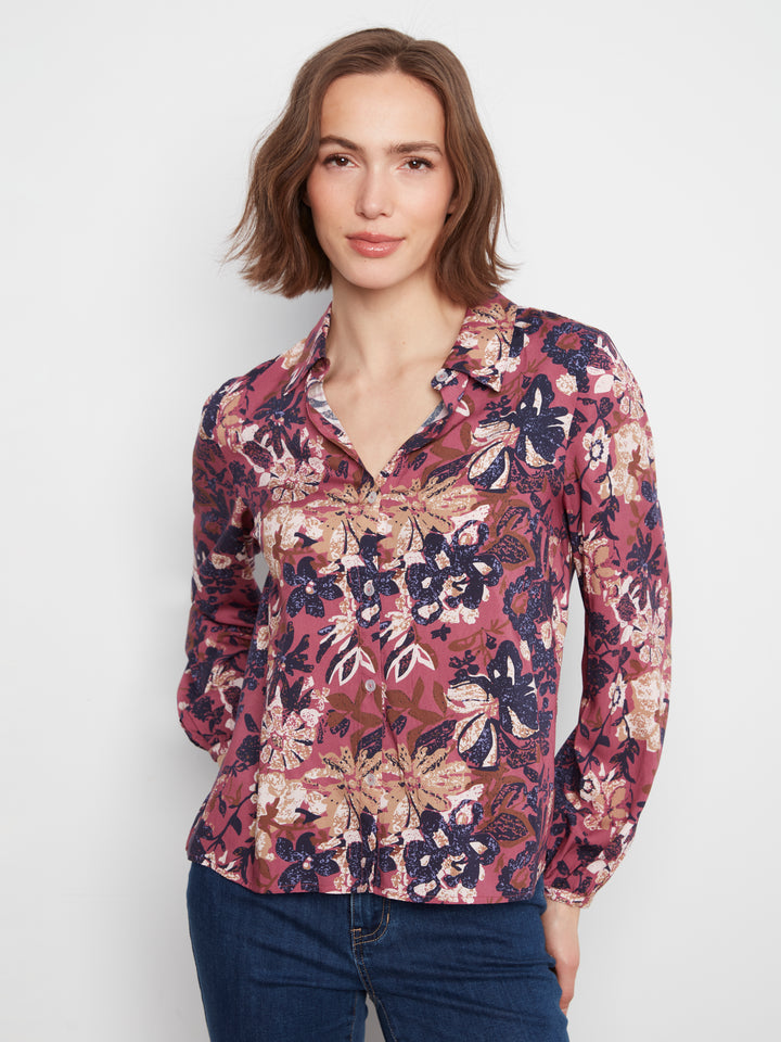 Woman wearing a floral blouse with a plain background