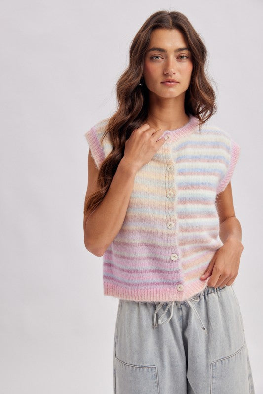 Woman wearing a pastel striped sleeveless sweater against a white background