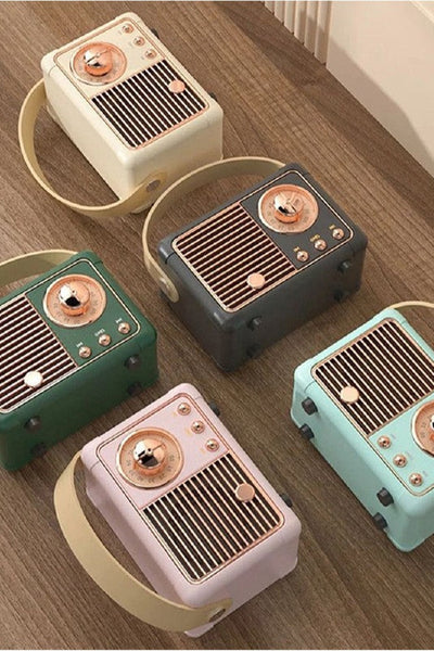 Set of retro-style mini speakers in various colors on a wooden surface.