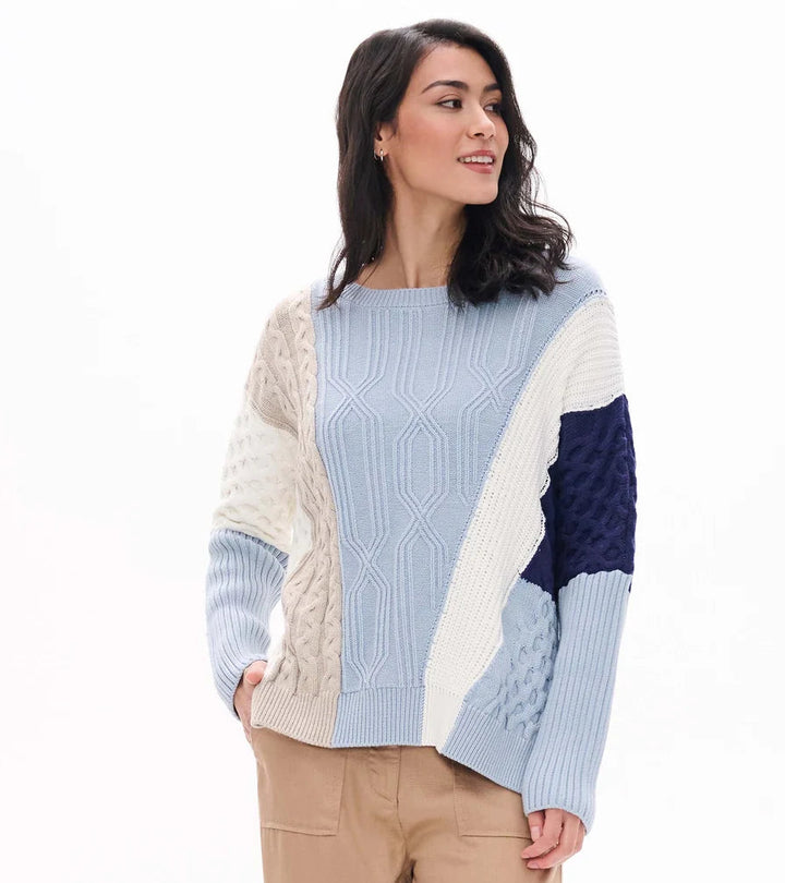 Woman wearing a colorful sweater with a white background