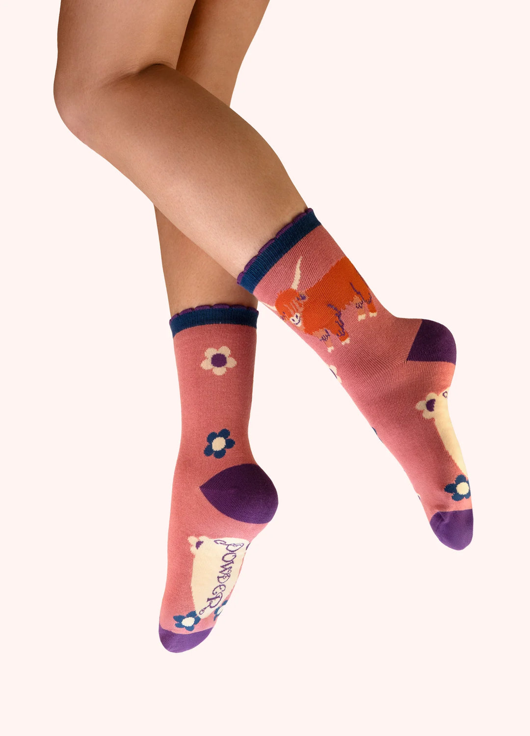 Colorful socks with floral designs worn by a person on a white background