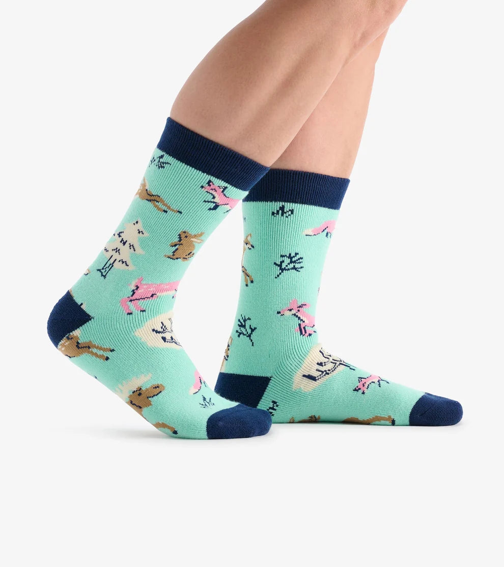 Teal socks with animal pattern worn by a person on a white background