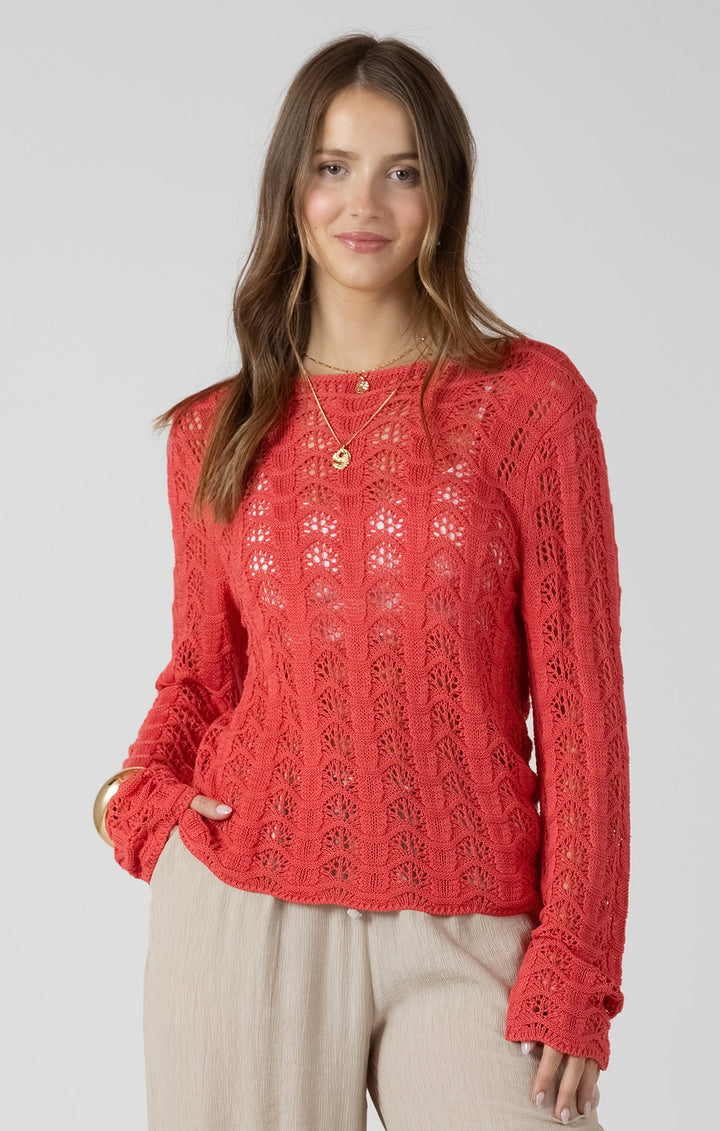 Woman wearing a red lace top and beige pants on a white background