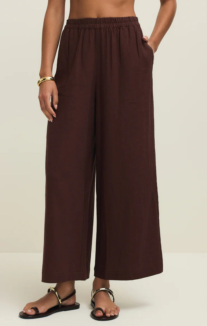 Brown wide-leg pants worn by a person on a white background