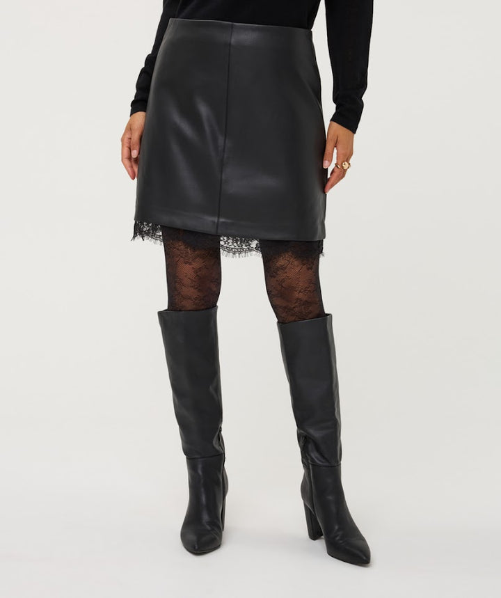 A model is shown from the waist down wearing a black faux-leather mini skirt with a lace hem, black lace tights, and black knee-high leather boots against a light gray studio background.