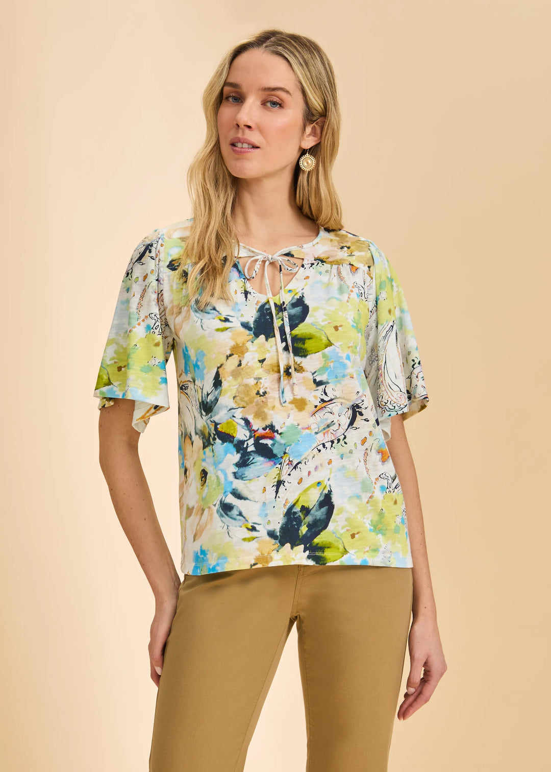 Woman wearing a colorful floral blouse with a beige background