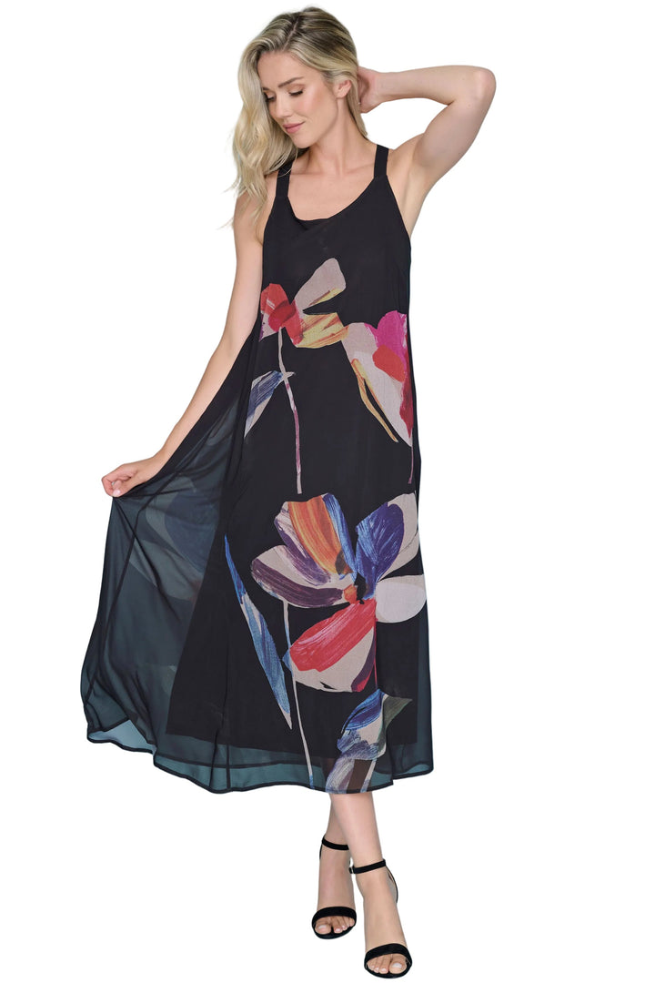 Woman wearing a black sleeveless dress with colorful floral patterns on a blue background