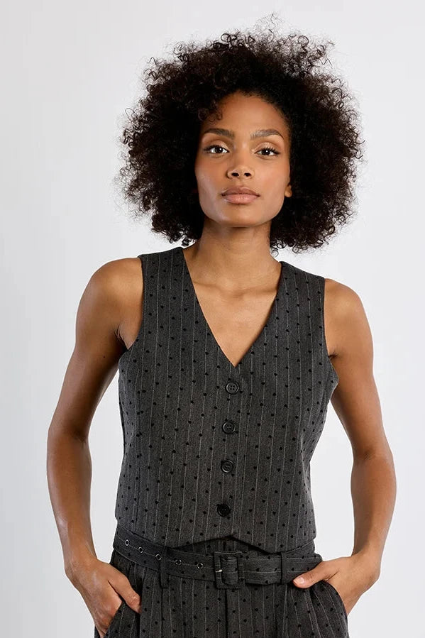 A woman modeling a dark gray sleeveless vest and matching shorts set with a subtle vertical dotted pattern, set against a plain white studio background.