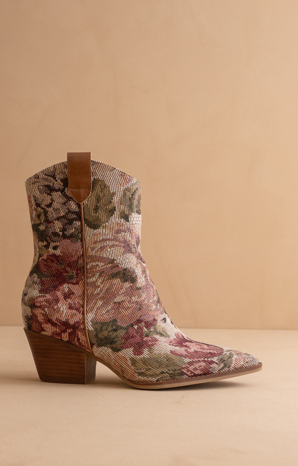 Floral patterned cowboy boot on a beige background