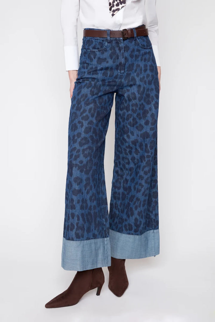 Blue leopard print pants worn by a person on a white background