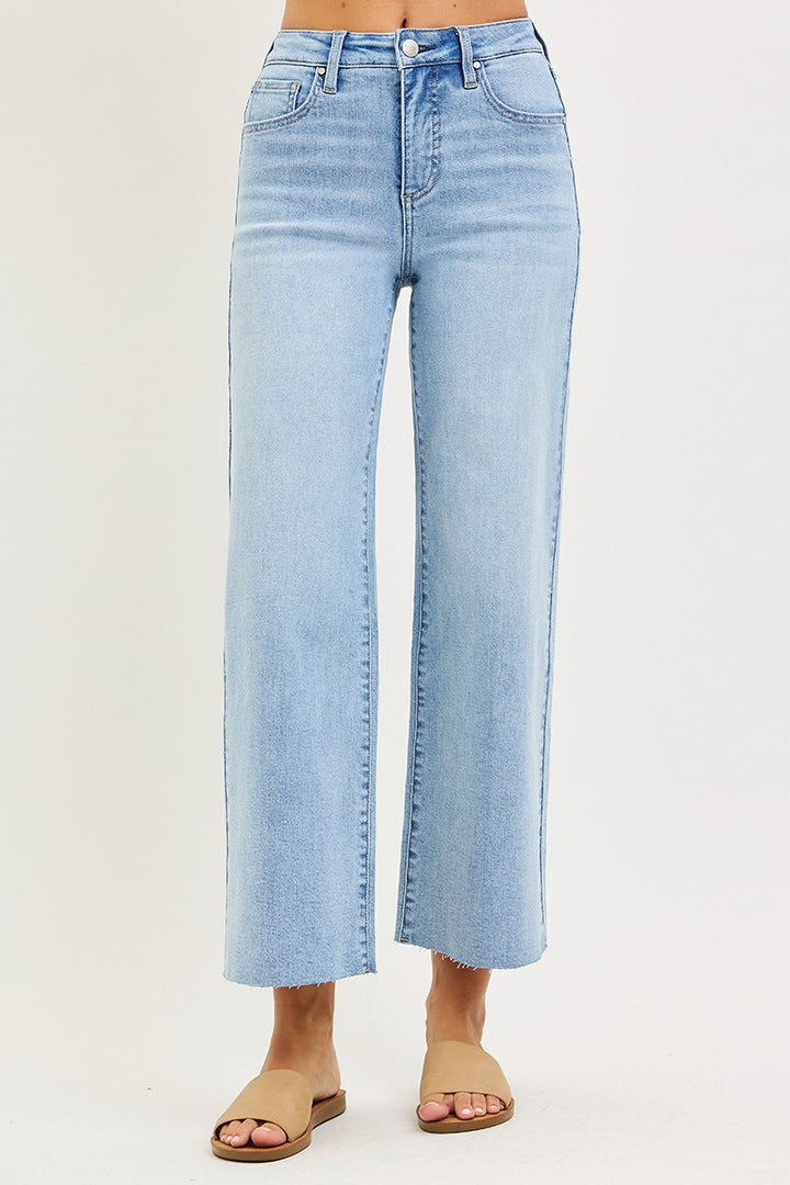Light blue jeans worn by a person on a plain background