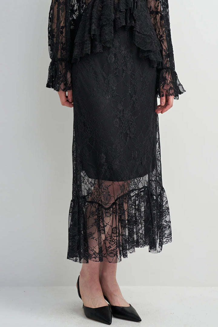Person wearing a black lace dress on a white background