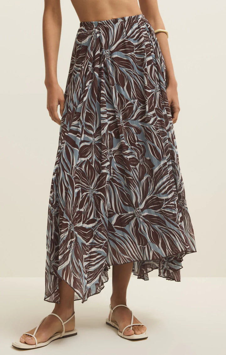 Person wearing a patterned skirt on a plain background