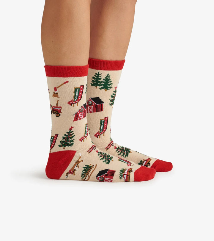 Beige socks with red accents and farm-themed design worn by a person on a white background