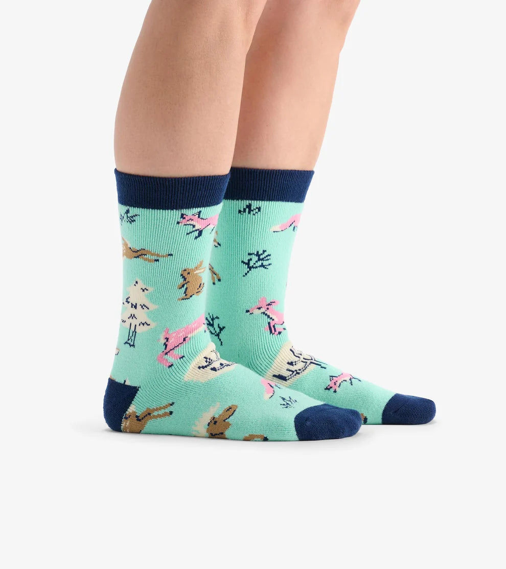 Teal socks with animal pattern worn by a person on a white background