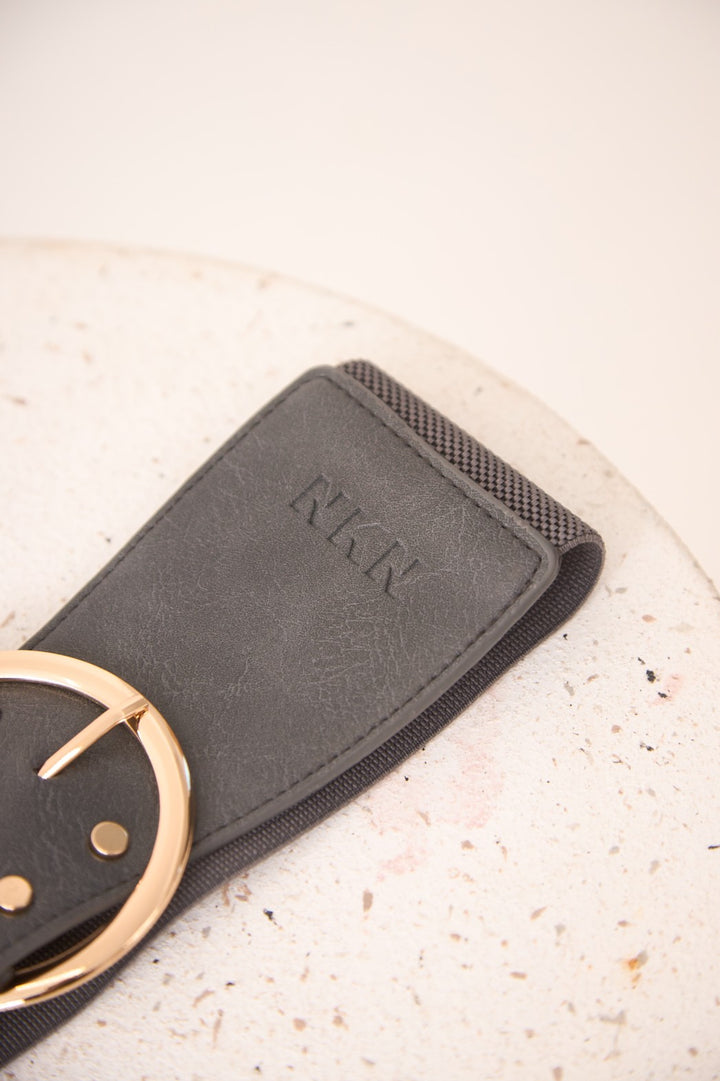 Gray belt with gold buckle on a textured surface