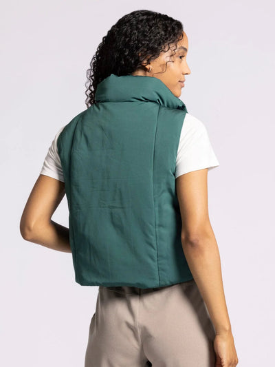 Person wearing a green vest on a plain background