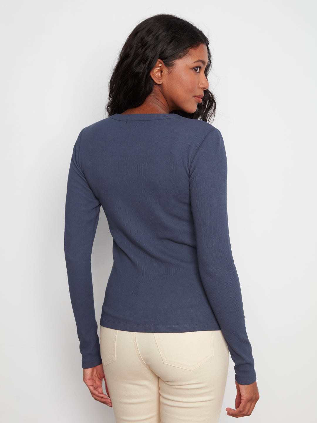 Woman wearing a blue long-sleeve shirt against a white background
