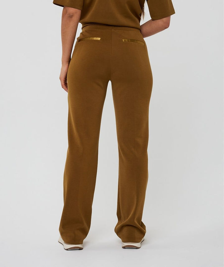 Brown pants worn by a person on a white background