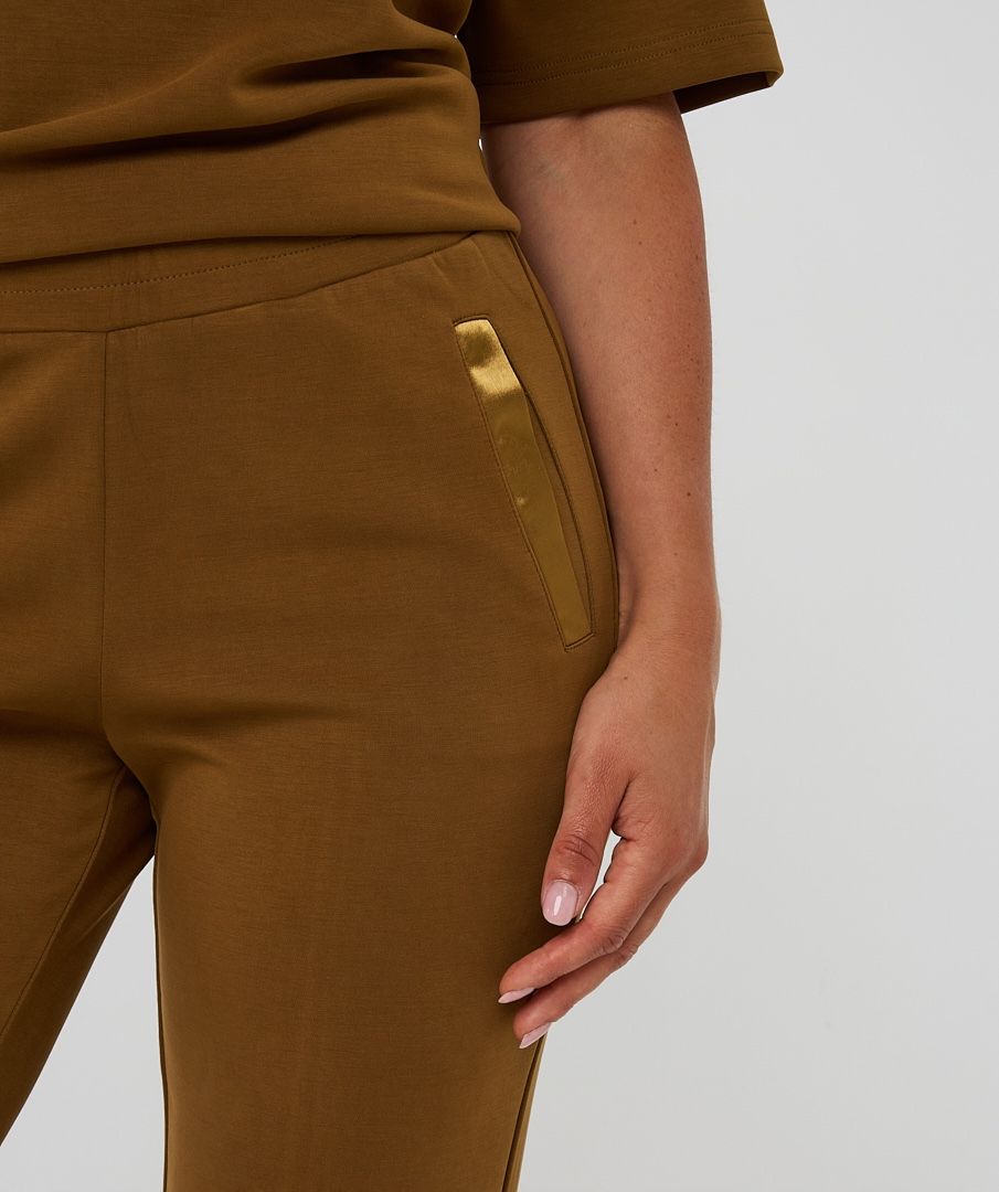 Brown pants with a pocket detail on a plain background