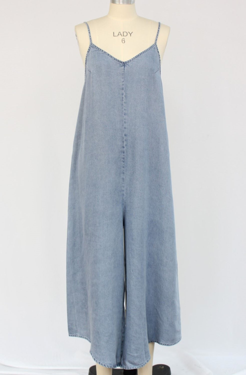 Blue denim jumpsuit on a mannequin against a white background