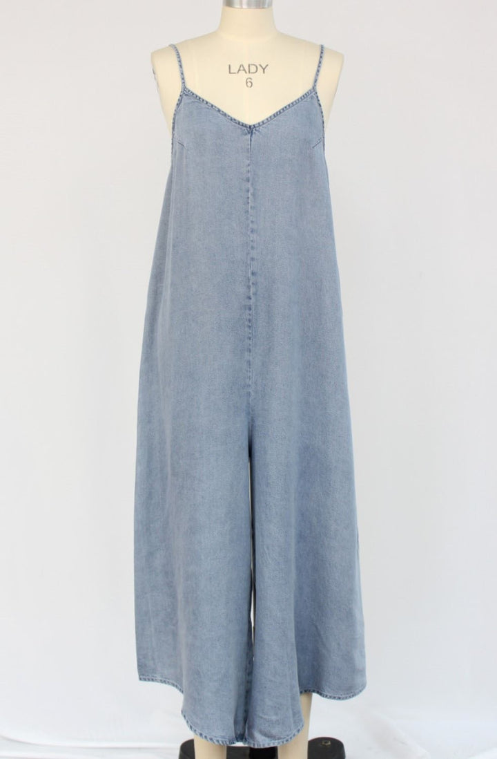 Blue denim jumpsuit on a mannequin against a white background