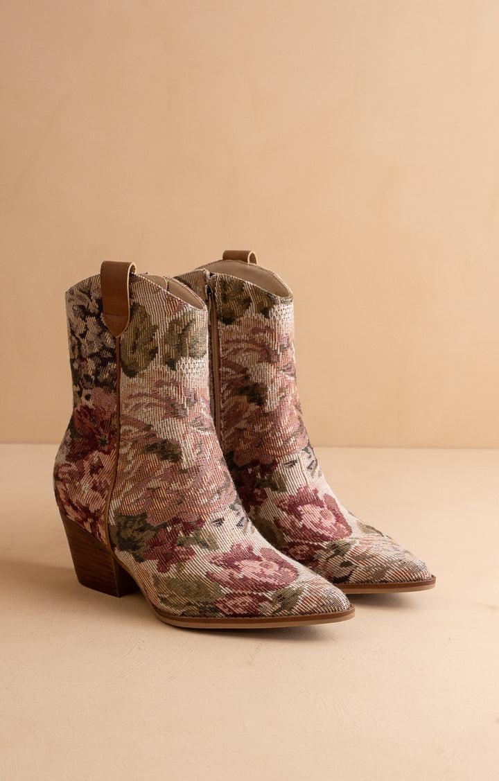 Floral patterned cowboy boots on a beige background