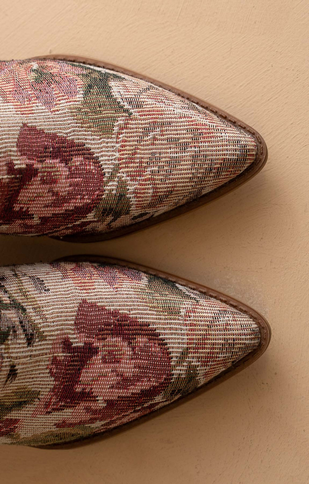 Pair of floral-pointed shoes on a beige background