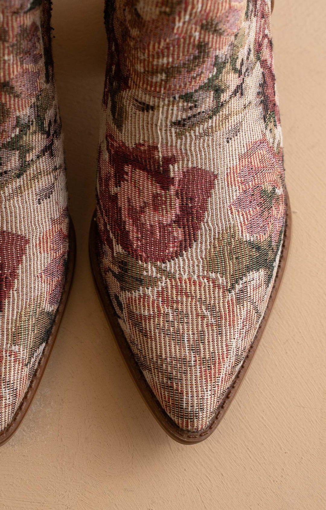 Pair of floral-patterned boots on a beige background