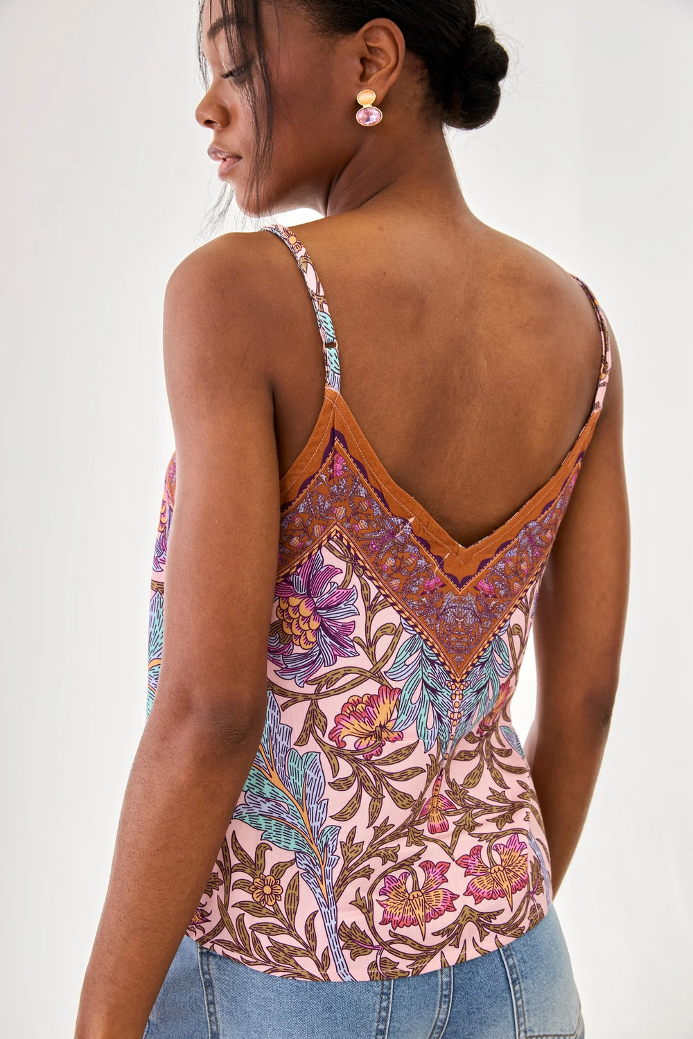 Woman wearing a colorful patterned tank top with a white background