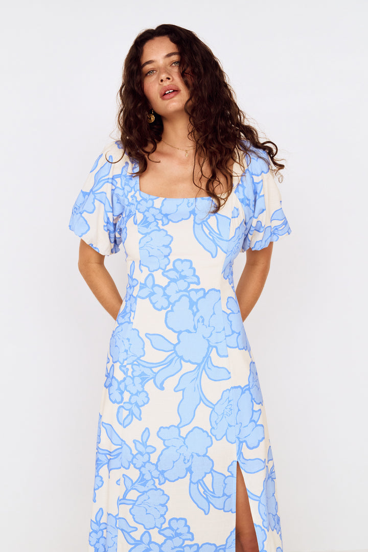 Woman wearing a blue floral dress on a white background